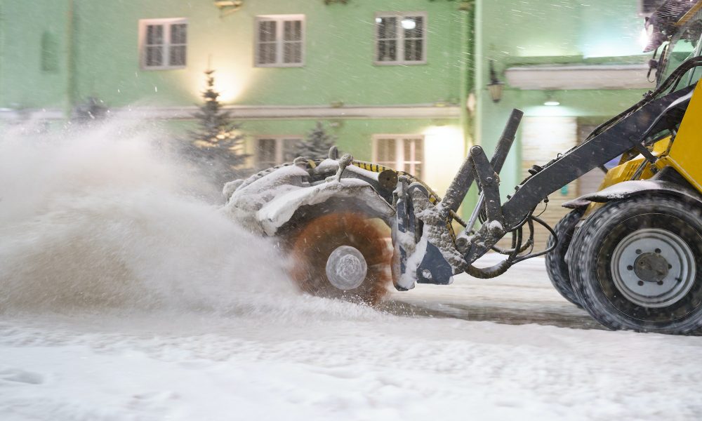 Cleaning snow from road. Snowplow tractor in city blow snow from street for transport traffic safety