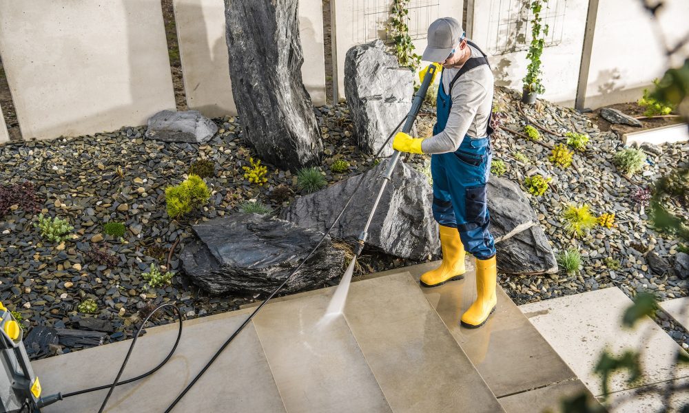 Worker Cleaning the Yard Around the House